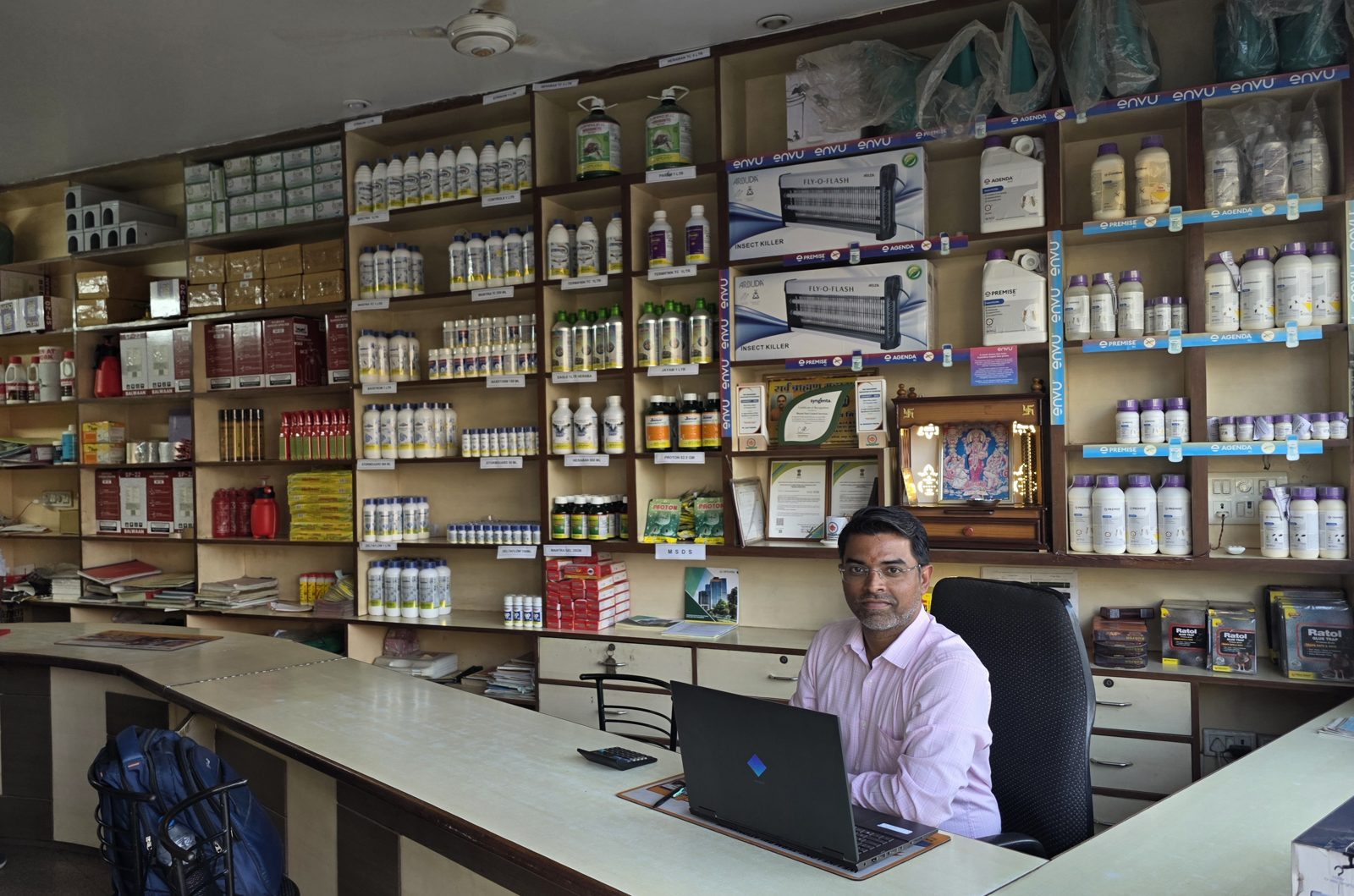 Bharat Pest Control Services team member at the Jaipur showroom desk with ENVU Premise, Agenda and Syngenta product shelves